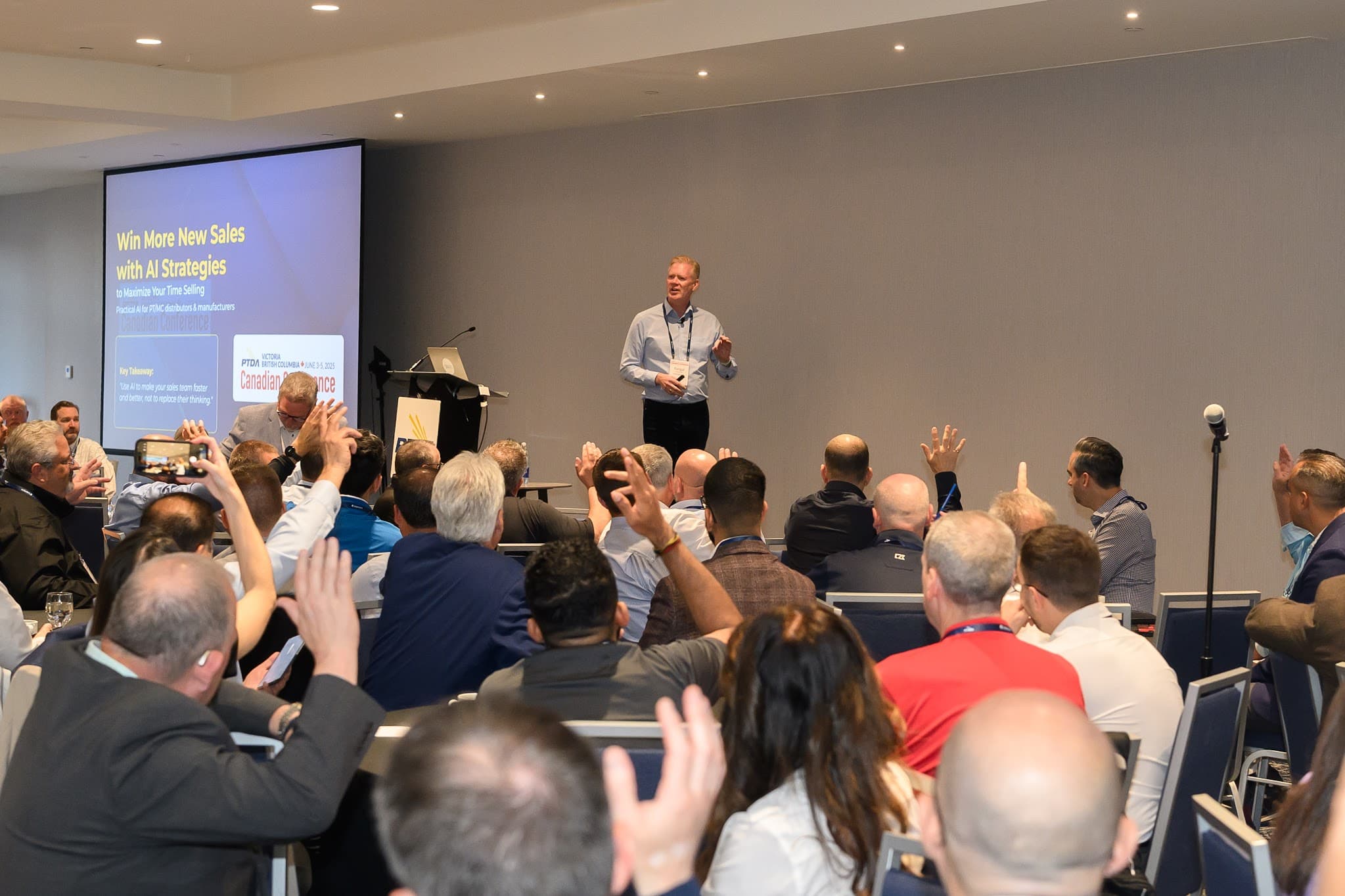 Audience members raising their hands during Fergal’s talk on winning new sales with AI strategies